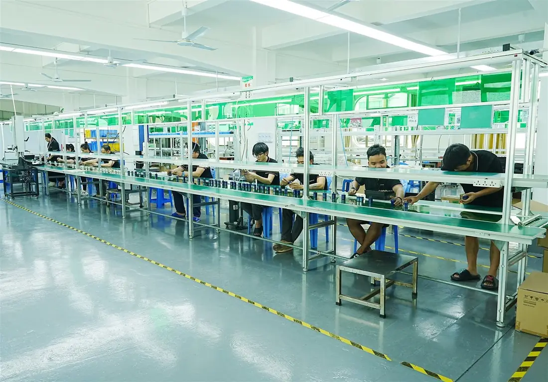 Long GaN charger assembly line with workers at green ESD benches in the Dongguan factory